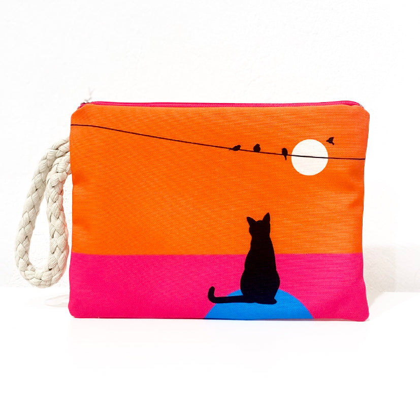 Cat catching colourful sunset clutch bag